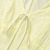 Close-up of a light yellow textured fabric with a drawstring.