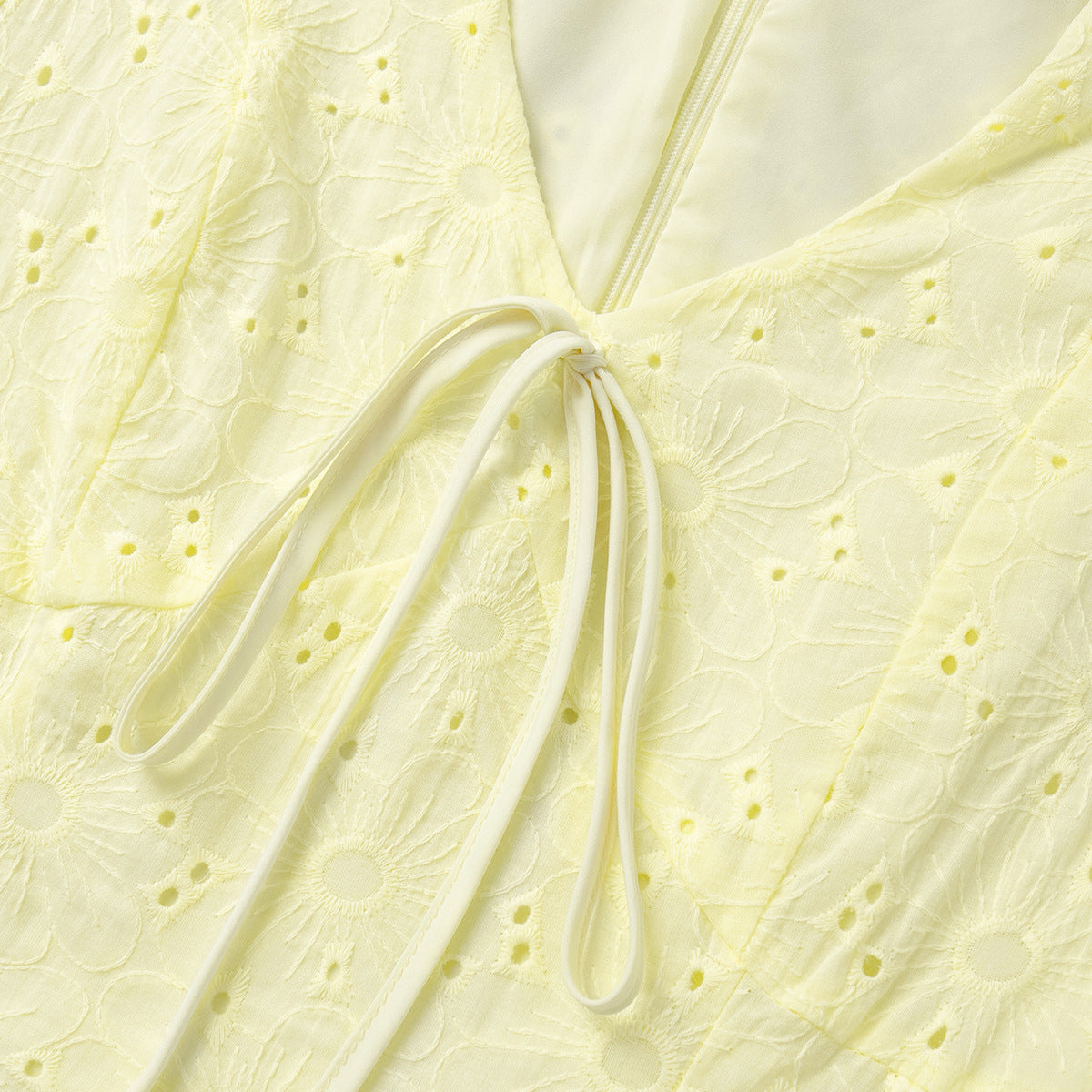 Close-up of a light yellow textured fabric with a drawstring.