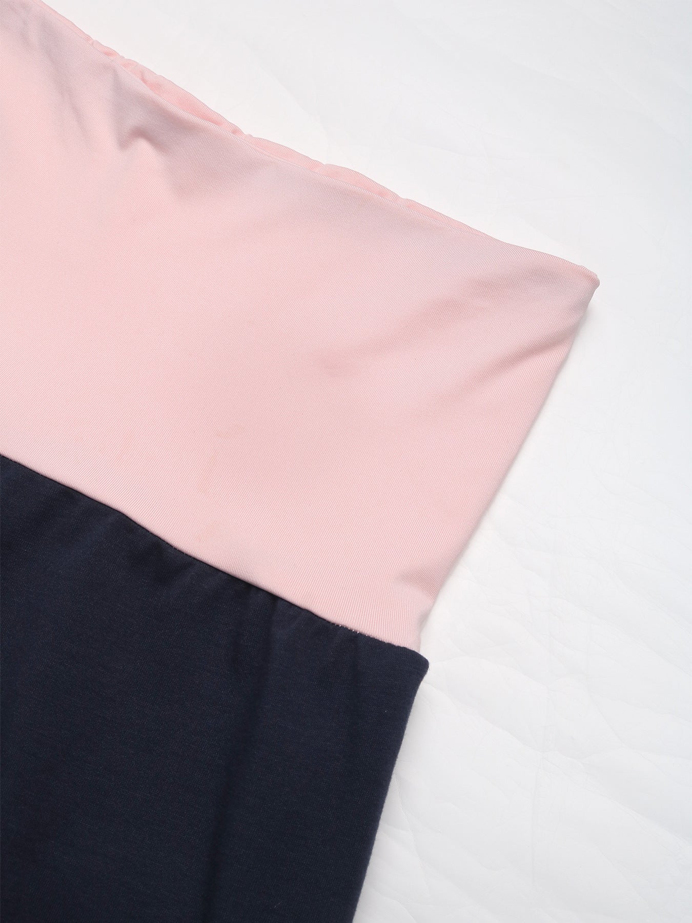 Close-up of pink waistband and navy blue fabric on wide-leg pants, highlighting the soft and stretchy material.