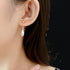 Two-tone gold and silver Water Drop dangle earrings on ear