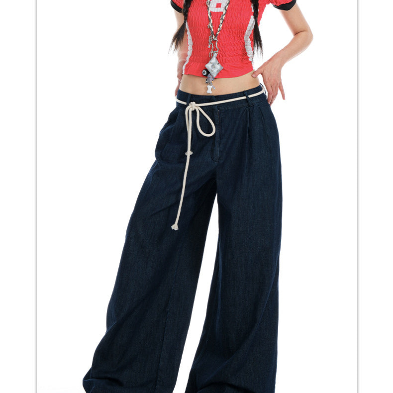 Cropped shot of model wearing dark wide-leg jeans, emphasizing rope-tied waist and relaxed fit.