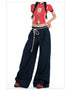 Cropped shot of model wearing dark wide-leg jeans, emphasizing rope-tied waist and relaxed fit.
