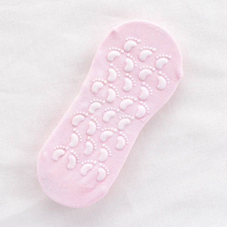 Light pink non-slip ankle sock with white footprint grip pattern on sole displayed flat against white fabric background