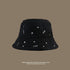 Black sherpa bucket hat with white embroidered star pattern and 'STARS' text detail against neutral taupe background