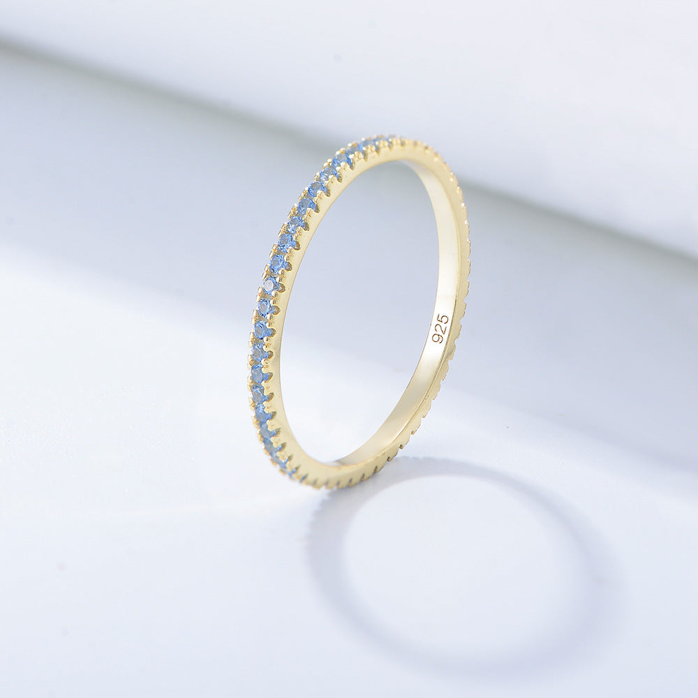 Light blue topaz eternity band in gold setting with delicate prong design and 925 stamp
