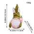 Easter gnome with an 8.86in (22.5cm) green hat, white bunny ears, tied fabric bow, white beard, and a pink flower.
