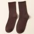 A pair of brown ribbed crew socks displayed flat against cream background showing texture and full length from side angle