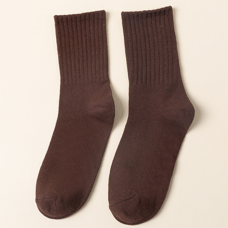 A pair of brown ribbed crew socks displayed flat against cream background showing texture and full length from side angle