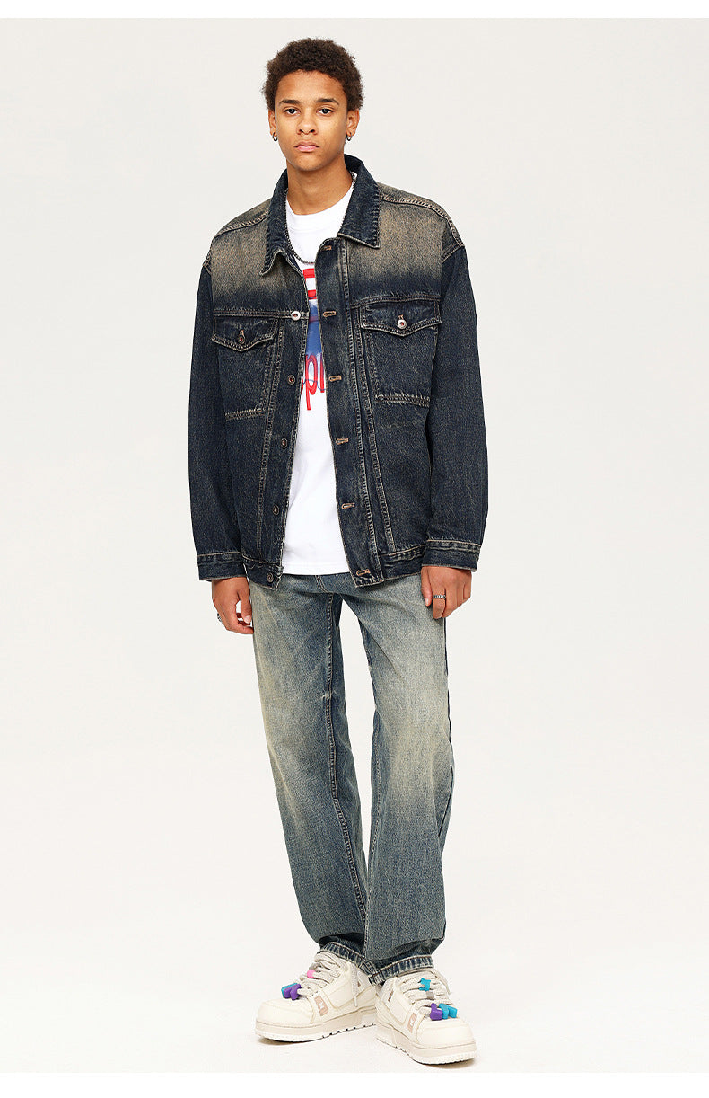 Model wearing wide leg distressed jeans with dark denim jacket and graphic tee, styled with white sneakers