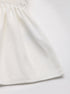 Close-up of the hem of the white peplum blouse, highlighting the soft flowy fabric.
