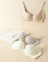 Three seamless bras in nude, white, and silver, displayed on a neutral background to highlight comfort and shaping.