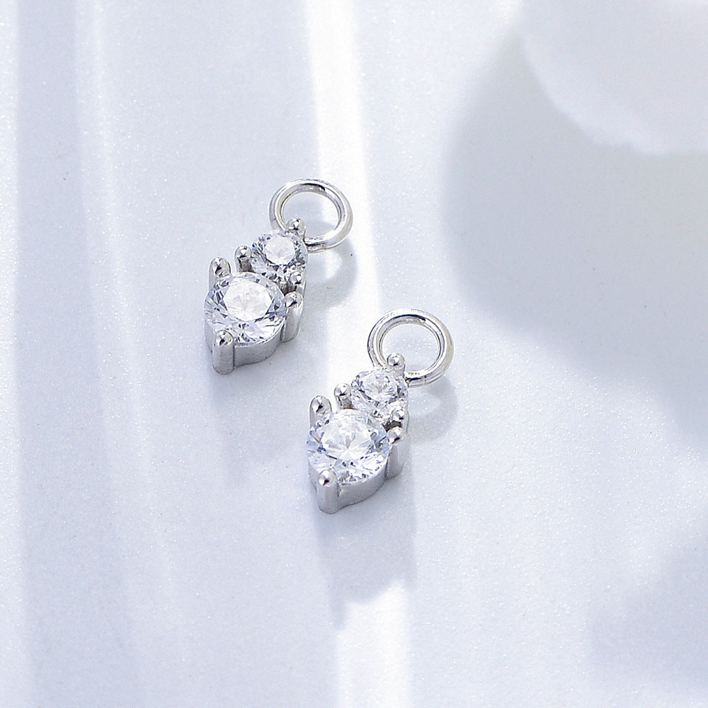 Silver diamond drop charms with double crystal stones in prong settings, photographed on white background in natural light