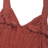 A close-up of the back of the jumpsuit, featuring ruched elastic and tied straps for an adjustable fit.