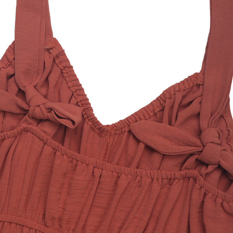 A close-up of the back of the jumpsuit, featuring ruched elastic and tied straps for an adjustable fit.