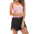 Pink ribbed camisole with lace trim worn with distressed black denim shorts