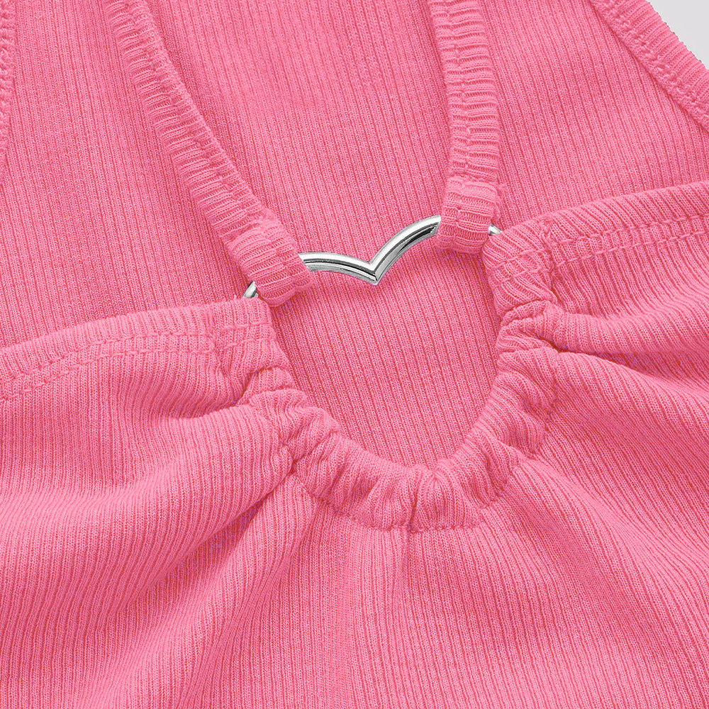 Close-up detail of pink ribbed crop top showing silver V-shaped metal connector and gathered elastic front with strap attachments