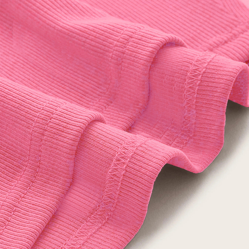 Pink ribbed knit fabric close-up showing stretchy textile texture and finished edge with decorative cross-stitching detail