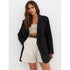Long black blazer paired with white high-waisted shorts, cream bandeau top, and brown leather belt, showcasing a chic layered outfit