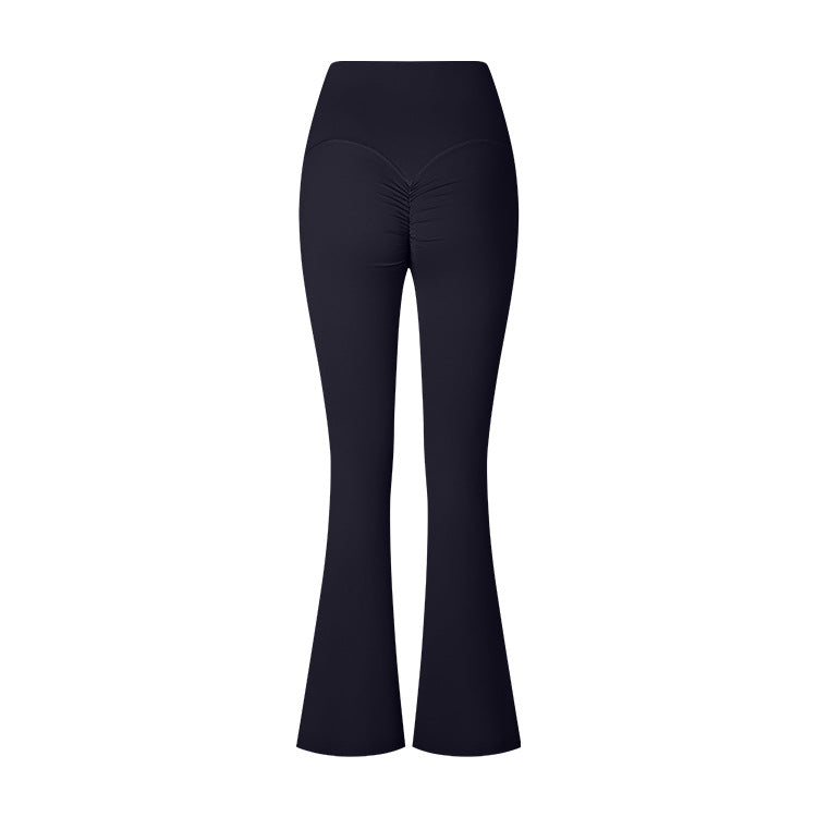 A product photo of black flared yoga pants with a high-rise waistband and ruched center detail, displayed flat against a white background