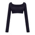 Black athletic crop top with long sleeves and ruched front detail, displayed on white background