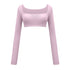 Soft pink athletic crop top with ruched front panel and long sleeves, product shot on white background