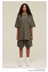Woman with curly hair modeling olive green oversized T-shirt and shorts set with white shoes