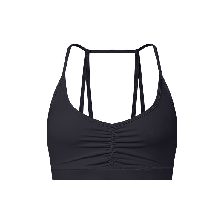 A black strappy sports bra with ruched center detail and slim double back straps displayed on white background