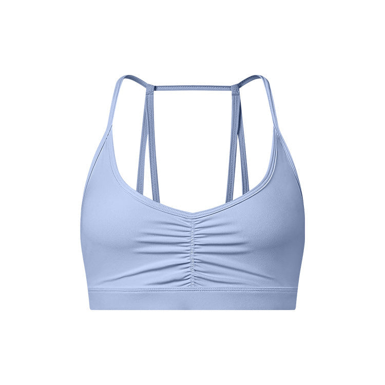 A light blue strappy sports bra with ruched center detail and thin double-strap design shown against white background