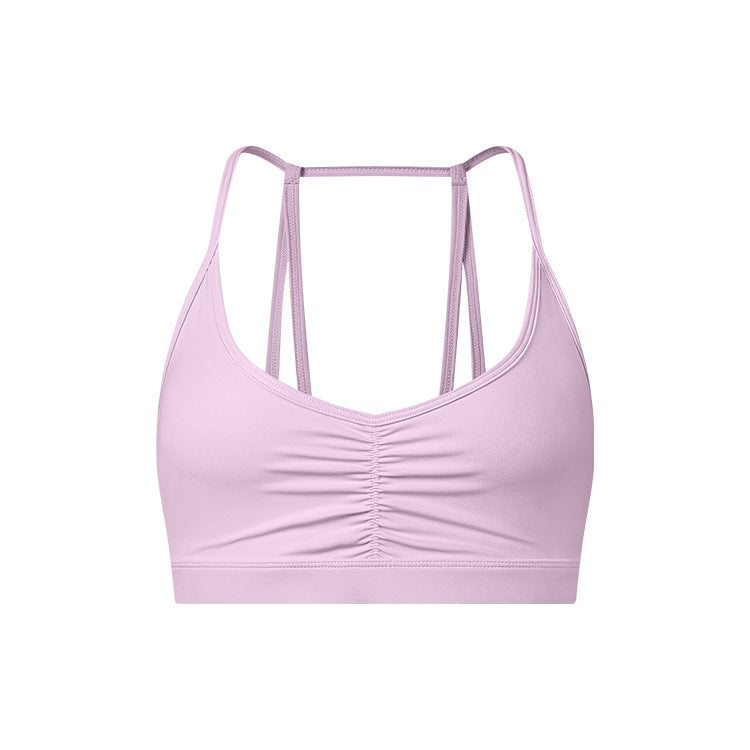A lavender strappy sports bra with ruched center detail and thin double-strap design displayed on white background