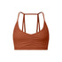 A terracotta strappy sports bra with ruched center detail and thin double-strap design shown against white background