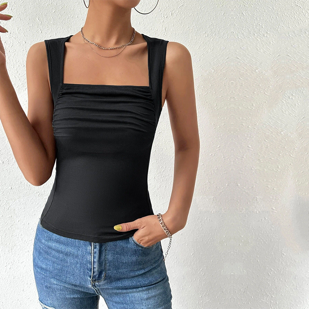 Side view of black tank top showing fitted silhouette, paired with distressed jeans and chain jewelry