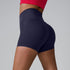Navy blue athletic shorts with high waist and contoured seams, shown from side angle with red sports top