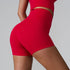 Red athletic shorts and matching sports bra set, shown from side angle with seamless design