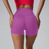 Purple high-waisted athletic shorts with back view detail, paired with red sports top