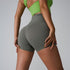 Olive green athletic shorts with contoured seams, paired with lime green sports top, back view