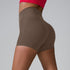 Taupe high-waisted compression shorts shown from side angle, styled with red sports top