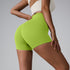Neon lime compression shorts with high waistband, paired with cream sports bra, side view on gray background