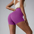 Purple high-waisted compression shorts with contoured design, paired with cream sports top, side profile view