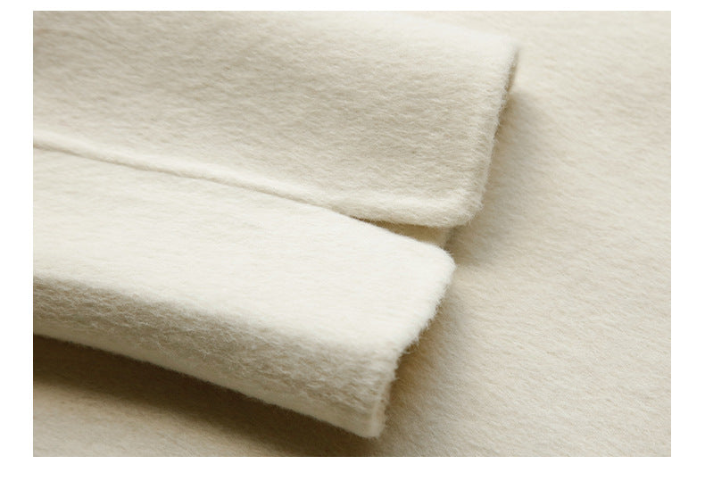 Close-up of clean finished seam on cream wool coat"