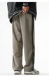 Back view of gray wide-leg pants with a pocket detail, paired with a black varsity jacket