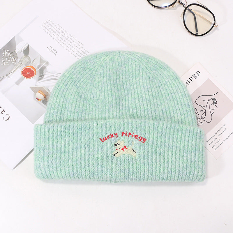 Mint green winter beanie with Lucky Pipiegg branding and puppy motif
