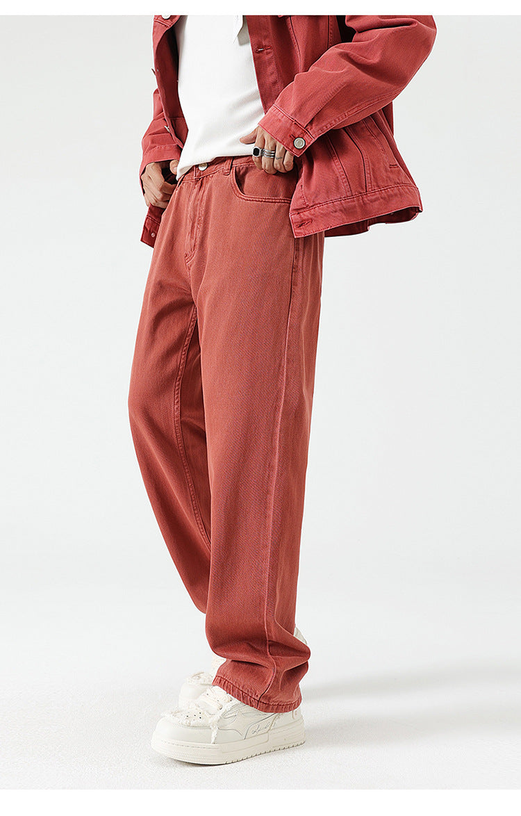 Rust-colored wide-leg jeans with relaxed fit, paired with matching jacket and white sneakers