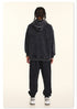 Rear view of model in black hoodie, showing textured fabric and braided hairstyle