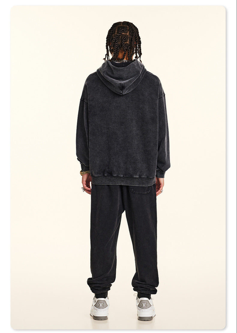 Rear view of model in black hoodie, showing textured fabric and braided hairstyle