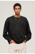 Close-up portrait of male model wearing black textured sweatshirt with decorative tabs and white pants