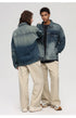 A woman with her back to camera and man facing forward pose against gray background. Both wearing gradient-wash denim jackets and beige wide-leg pants