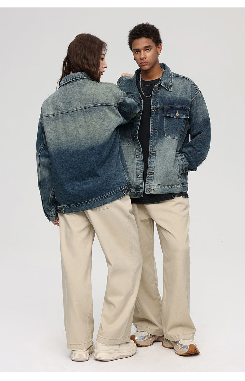 A woman with her back to camera and man facing forward pose against gray background. Both wearing gradient-wash denim jackets and beige wide-leg pants