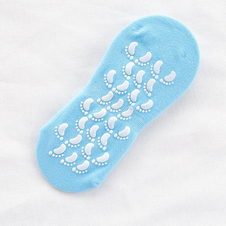 Light blue non-slip ankle sock with white footprint grip pattern on sole displayed flat against white fabric background