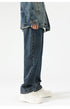 A model is standing wearing oversized straight-cut denim jeans with a denim jacket, showcasing the relaxed silhouette against white