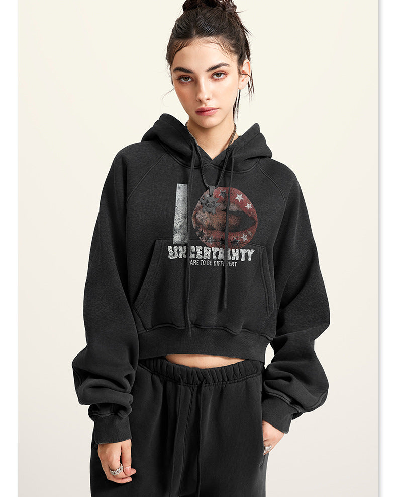 Black cropped hoodie with graphic print, model front view